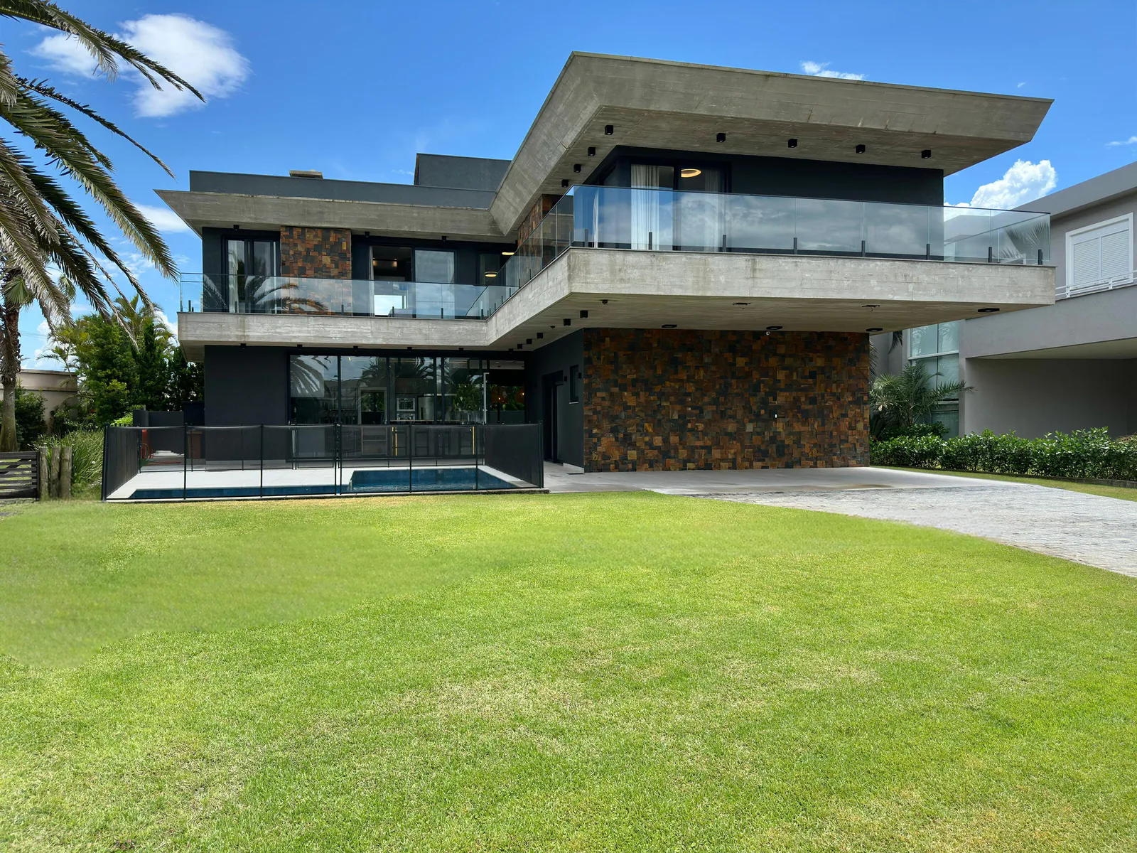 Fachada contemporânea da Residência Playa Vista diante do jardim e da piscina
