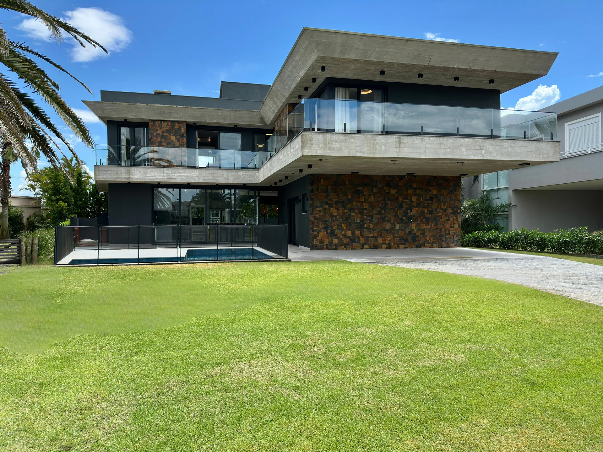 Fachada contemporânea da Residência Playa Vista diante do jardim e da piscina