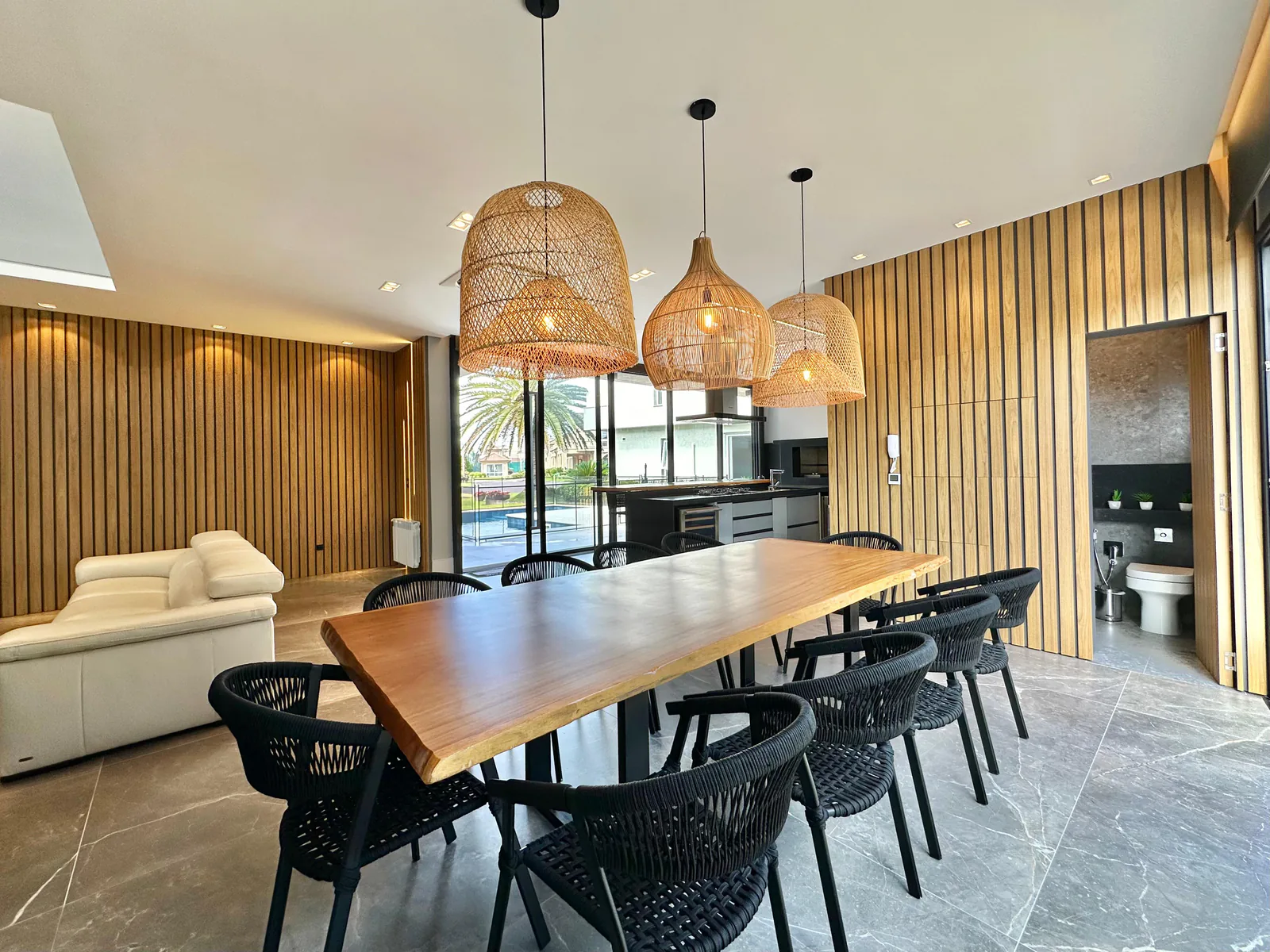 Sala de jantar com mesa de madeira e painel ripado