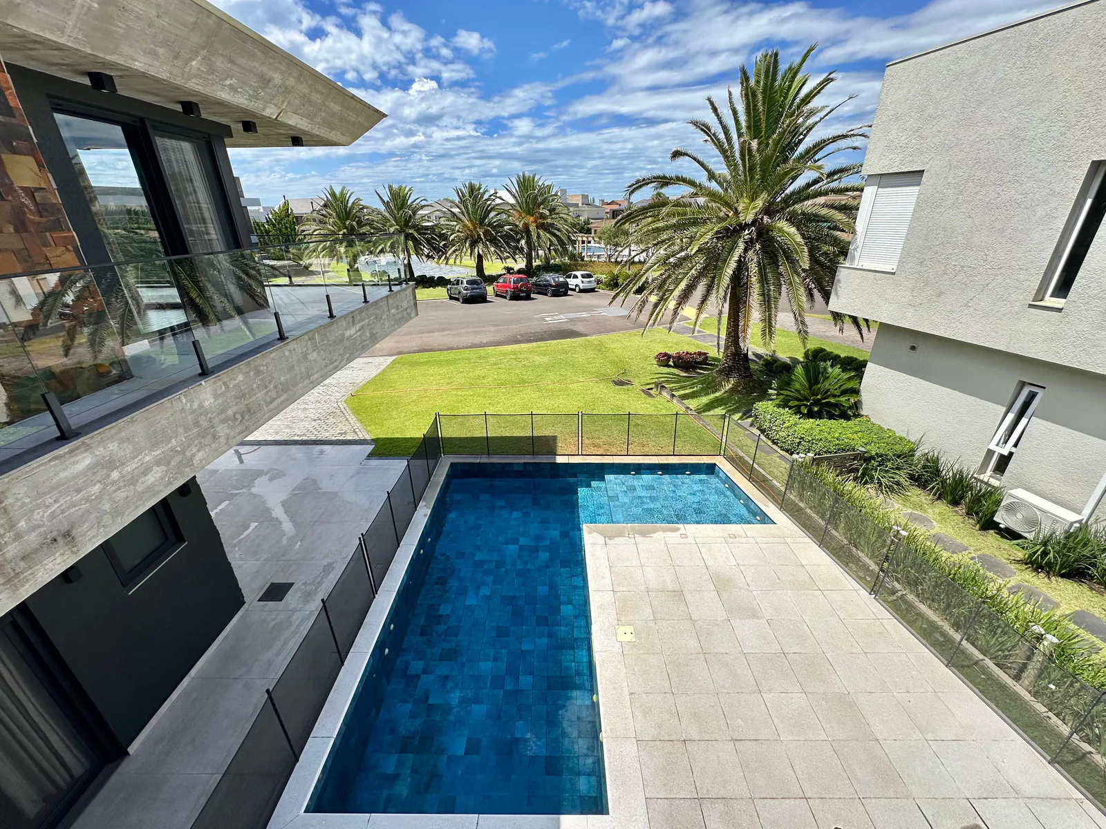 Piscina, jardim e fachada vistos do pavimento superior
